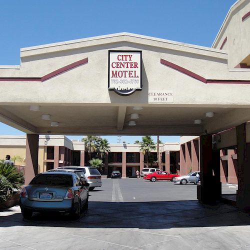 The image shows the entrance of the City Center Motel with several parked cars and palm trees in the background.